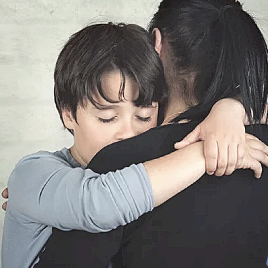 Boy hugging mom